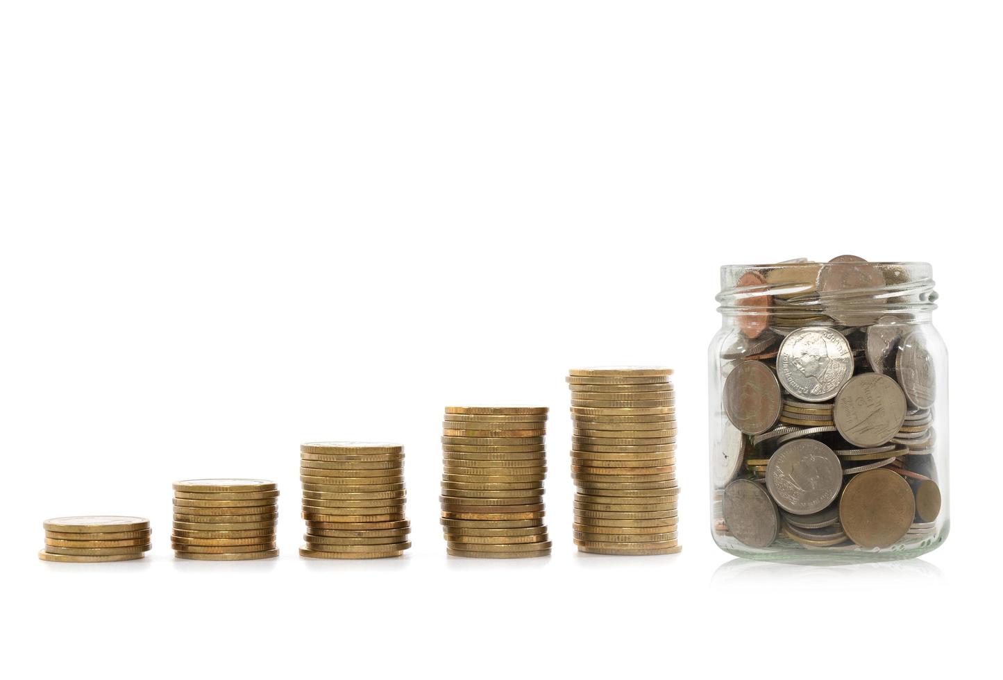 Gold coin in glass bottle with coin stacks on a white background.Saving money concept. photo