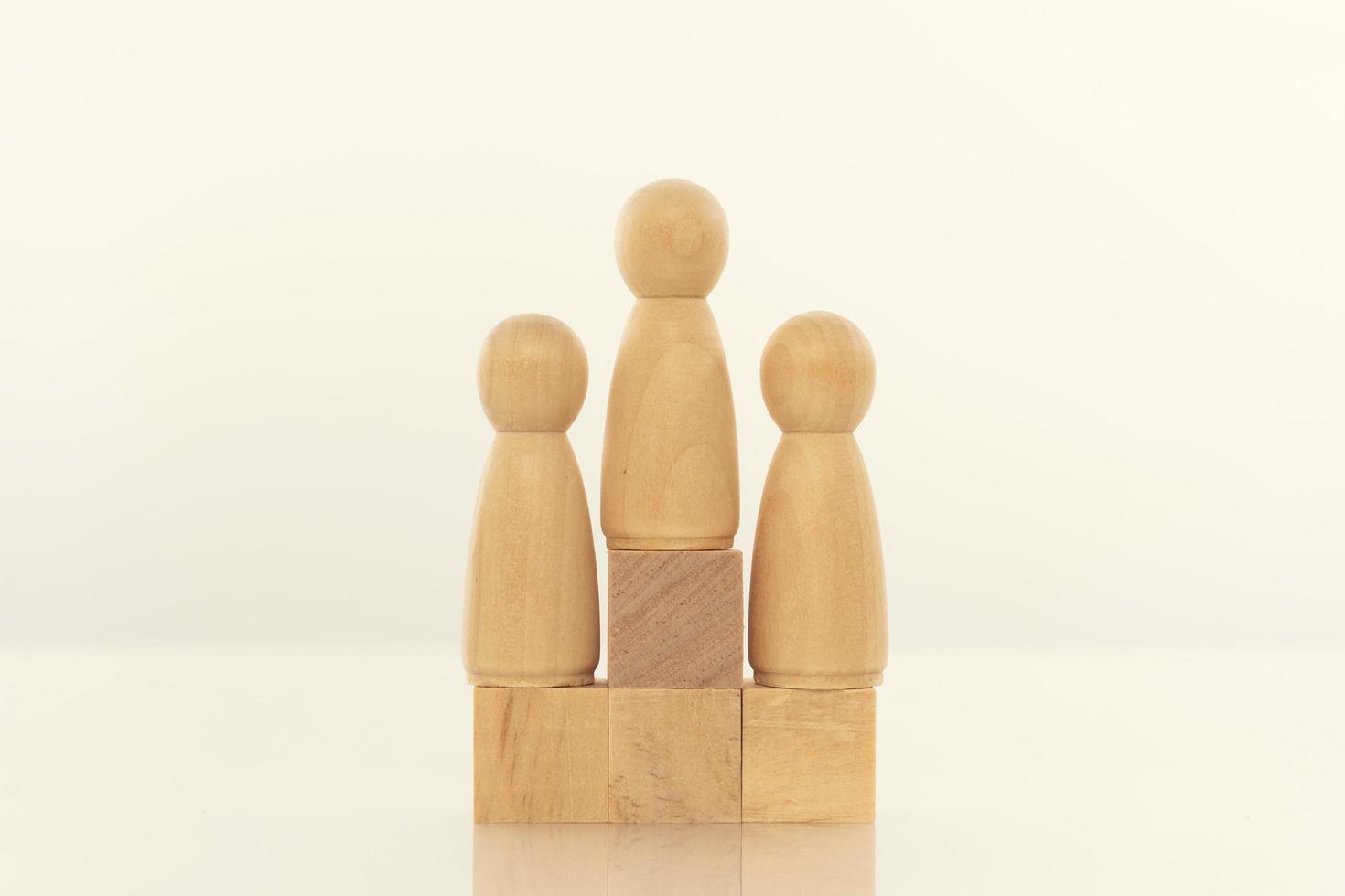 Leadership concept. Wood person model among people on white background. photo