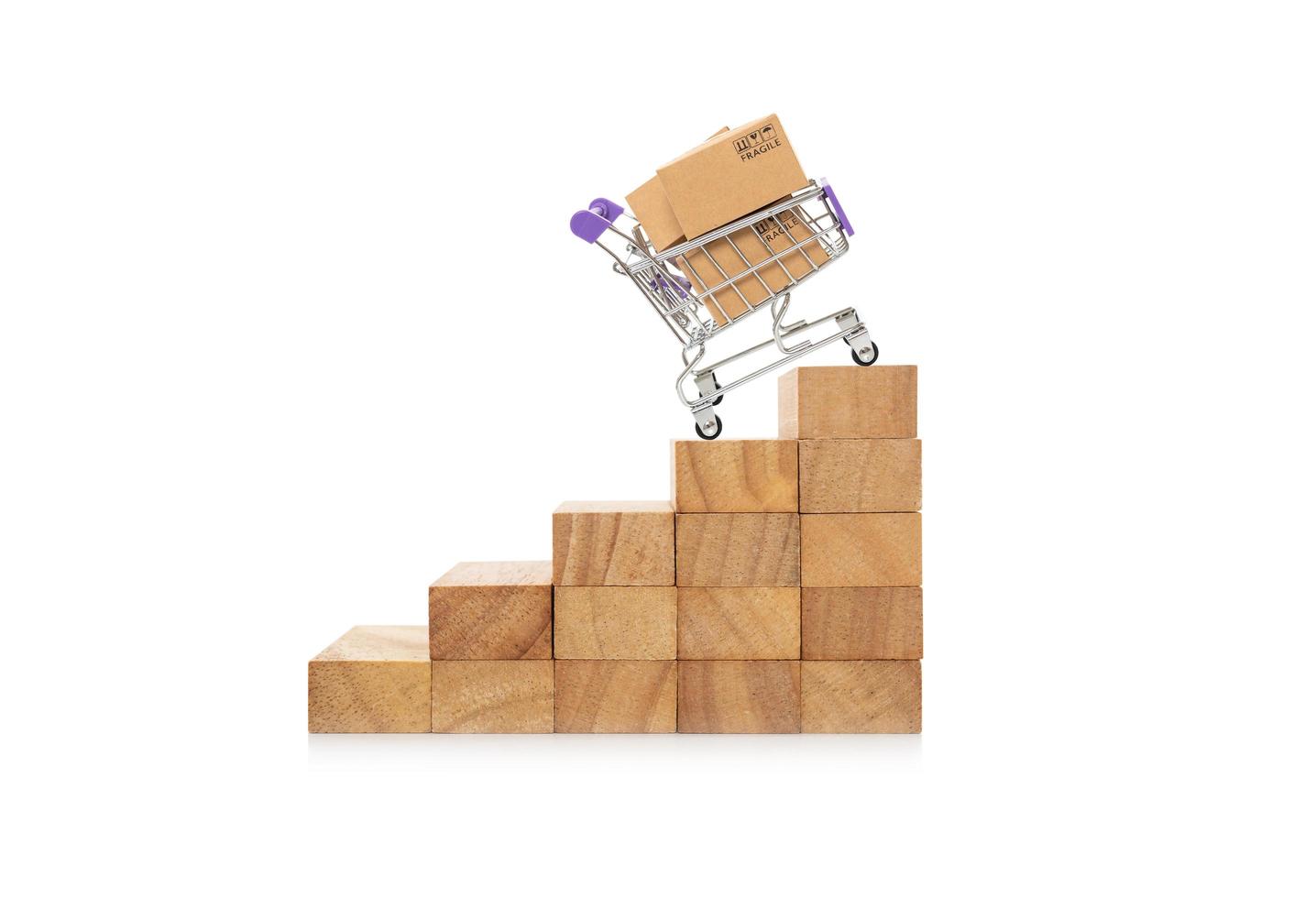 Paper boxes in a trolley on wooden block.online shopping concept growth success process photo