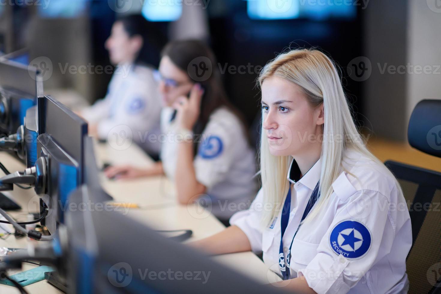Female operator working in a security data system control room photo