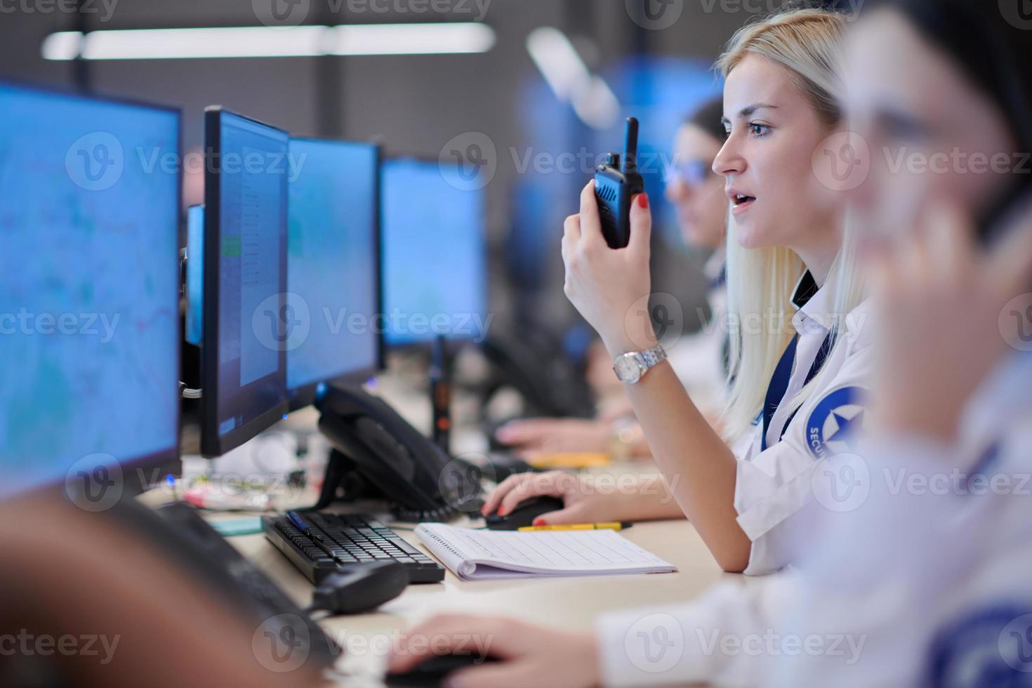 Female operator working in a security data system control room photo