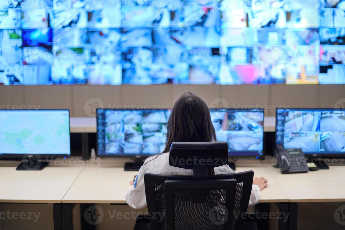 Female operator working in a security data system control room photo