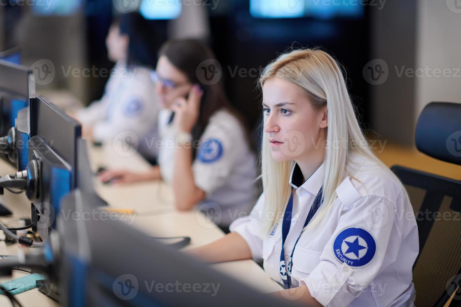 Female operator working in a security data system control room photo