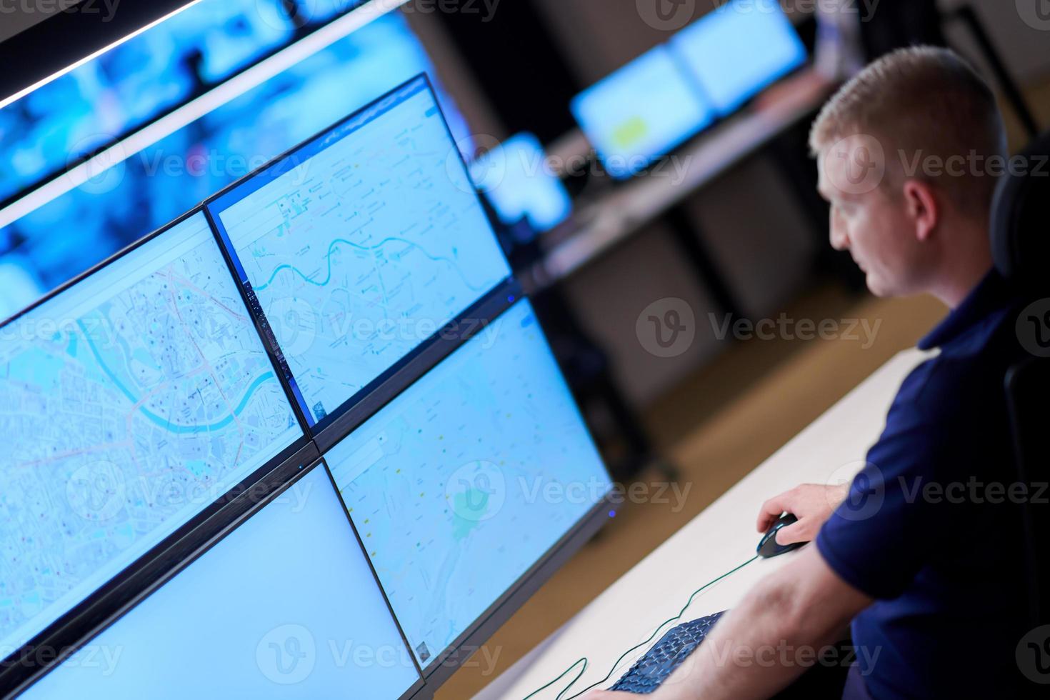 male operator working in a security data system control room photo