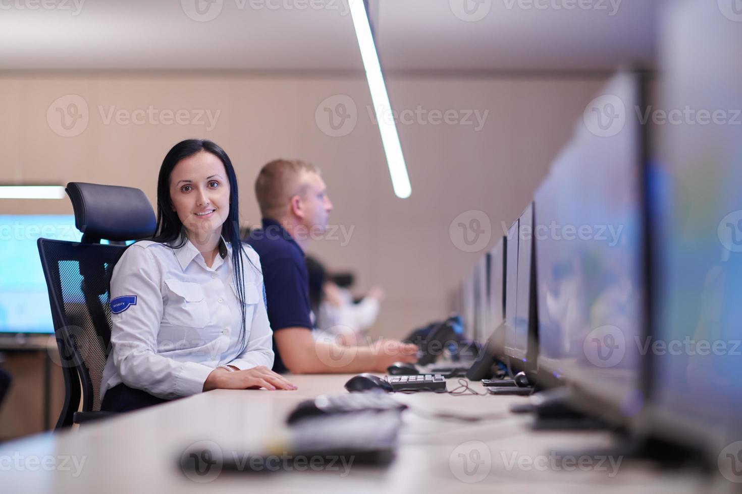 Female operator working in a security data system control room photo