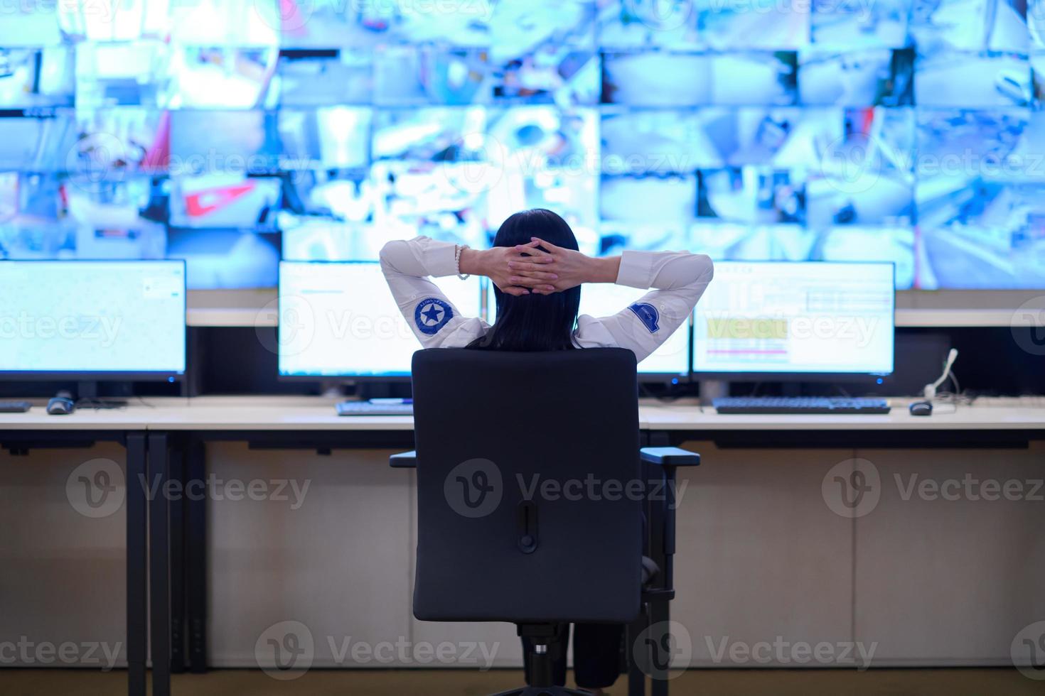 Female operator working in a security data system control room photo