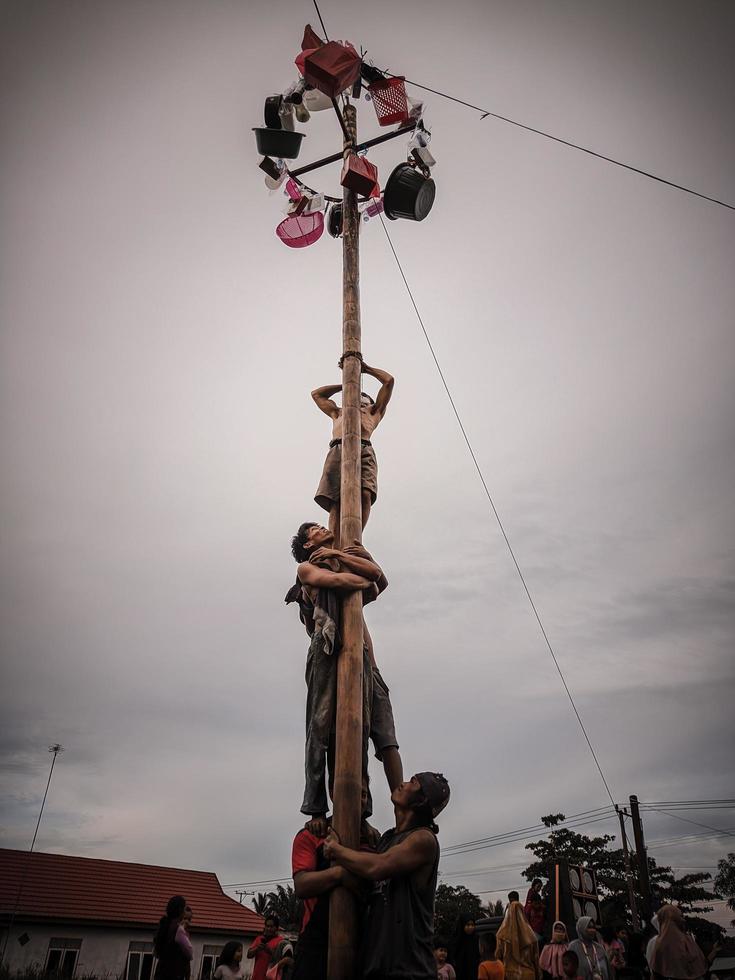 the excitement of children and adults taking part in the areca climbing competition to enliven the independence day of the republic of Indonesia, east kalimantan, indonesia, august, 14,2022 photo