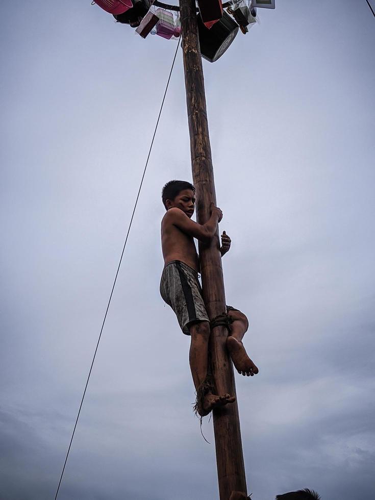 the excitement of children and adults taking part in the areca climbing competition to enliven the independence day of the republic of Indonesia, east kalimantan, indonesia, august, 14,2022 photo