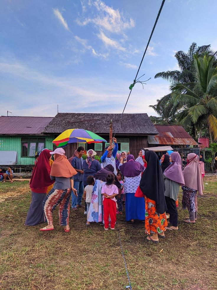 the excitement of adults and children taking part in a cracker eating competition to enliven the independence day of the republic of Indonesia, East Kalimantan, Indonesia August 13, 2022 photo