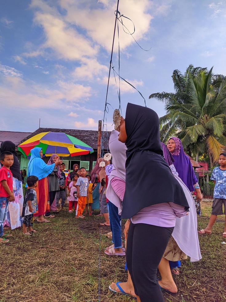 the excitement of adults and children taking part in a cracker eating competition to enliven the independence day of the republic of Indonesia, East Kalimantan, Indonesia August 13, 2022 photo