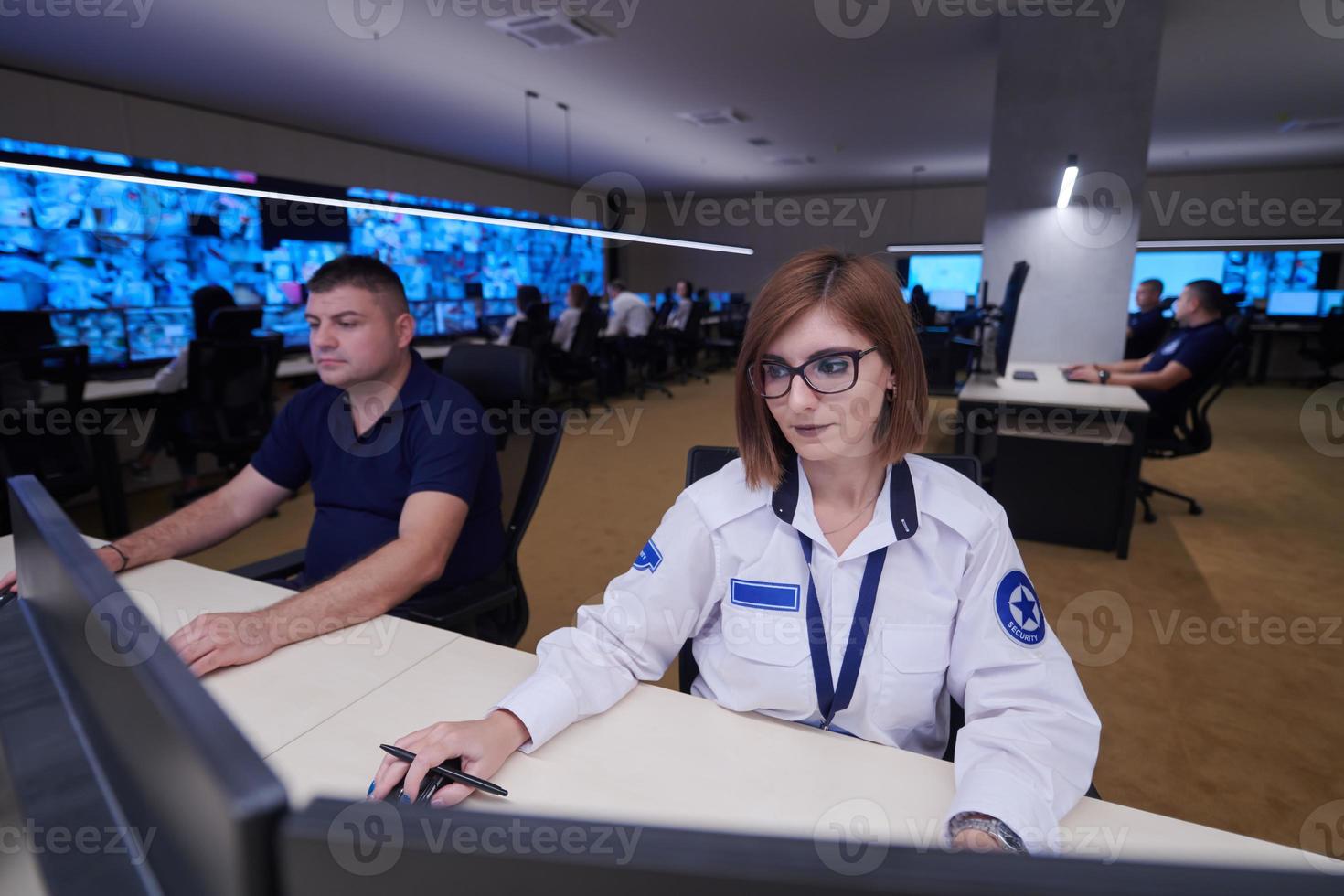 Female operator working in a security data system control room photo