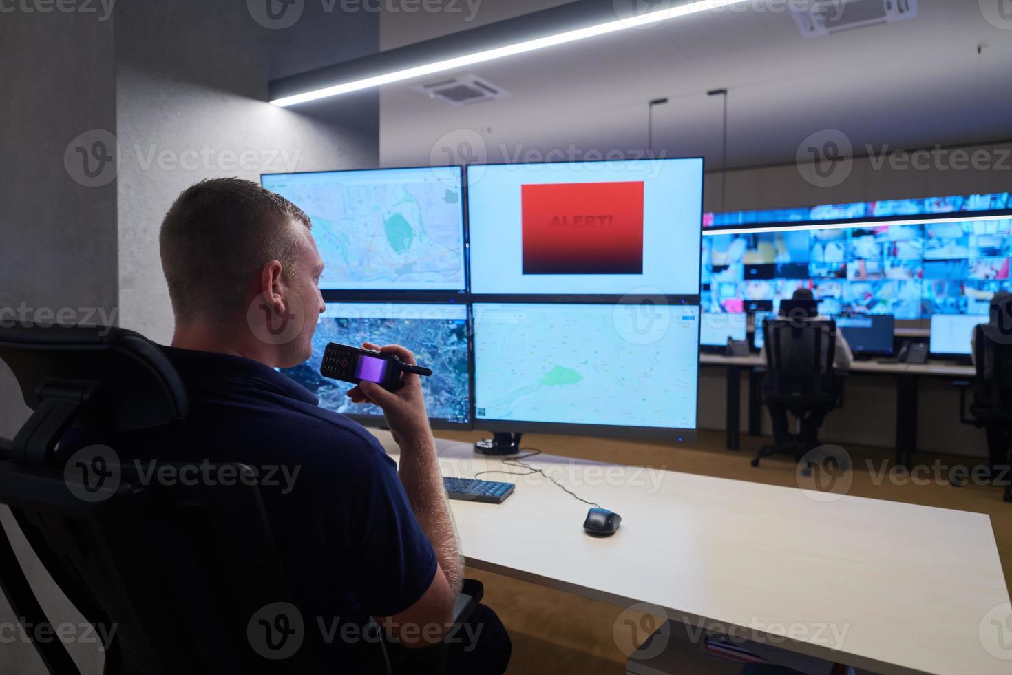 young male operator working in a security data system control room photo