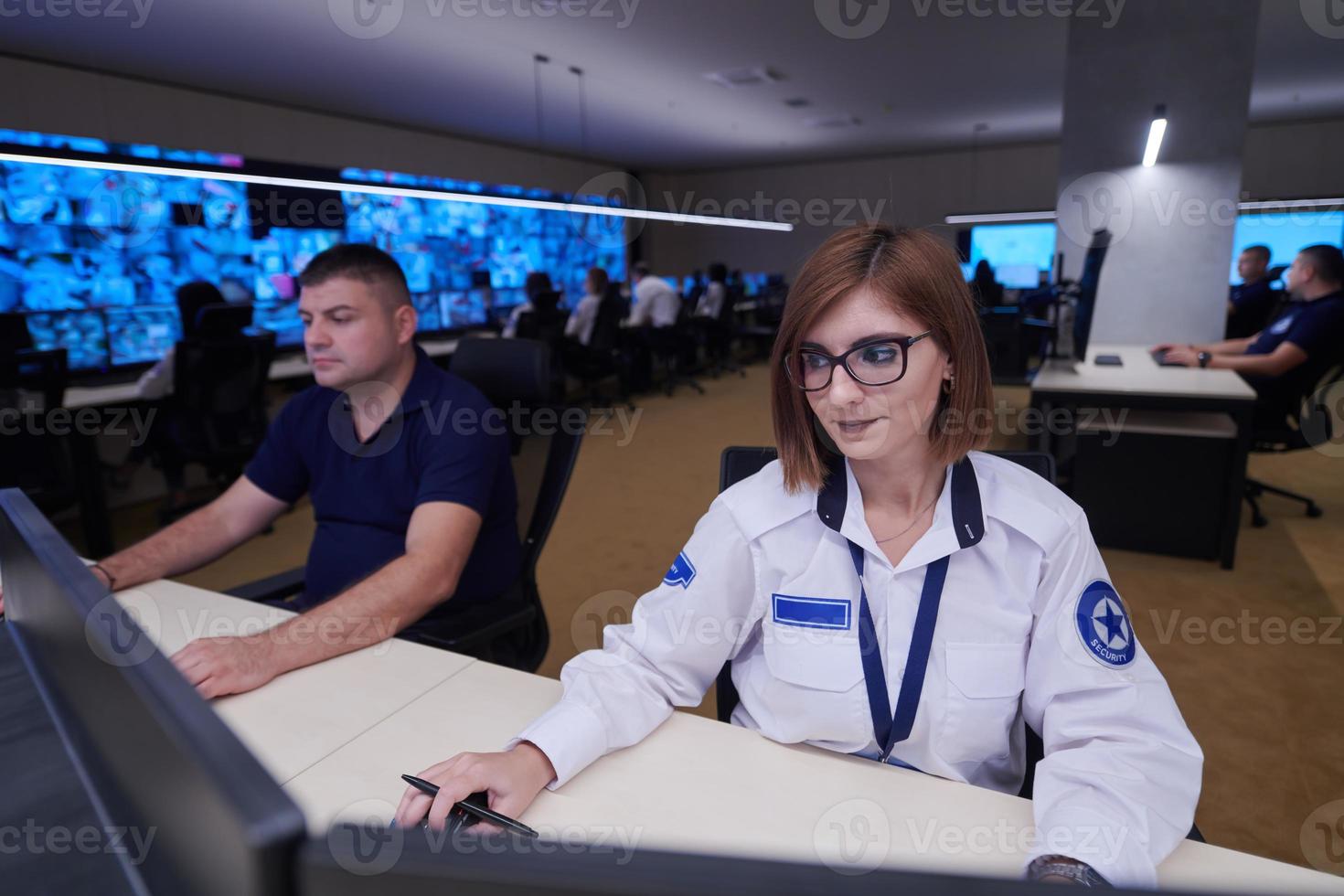 Female operator working in a security data system control room photo