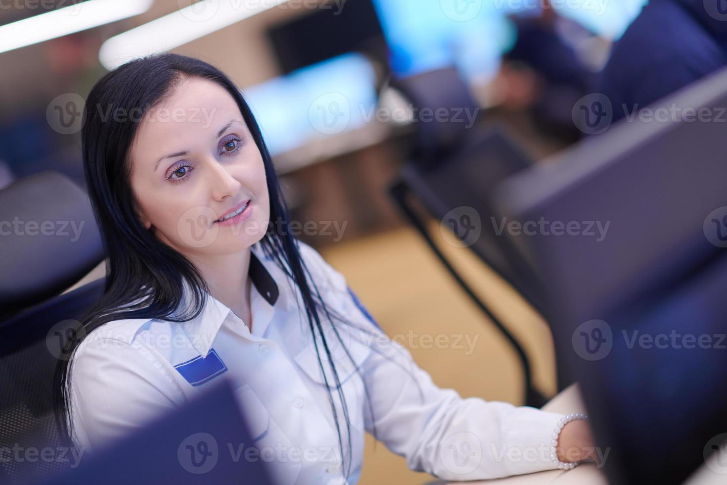 Female operator working in a security data system control room photo
