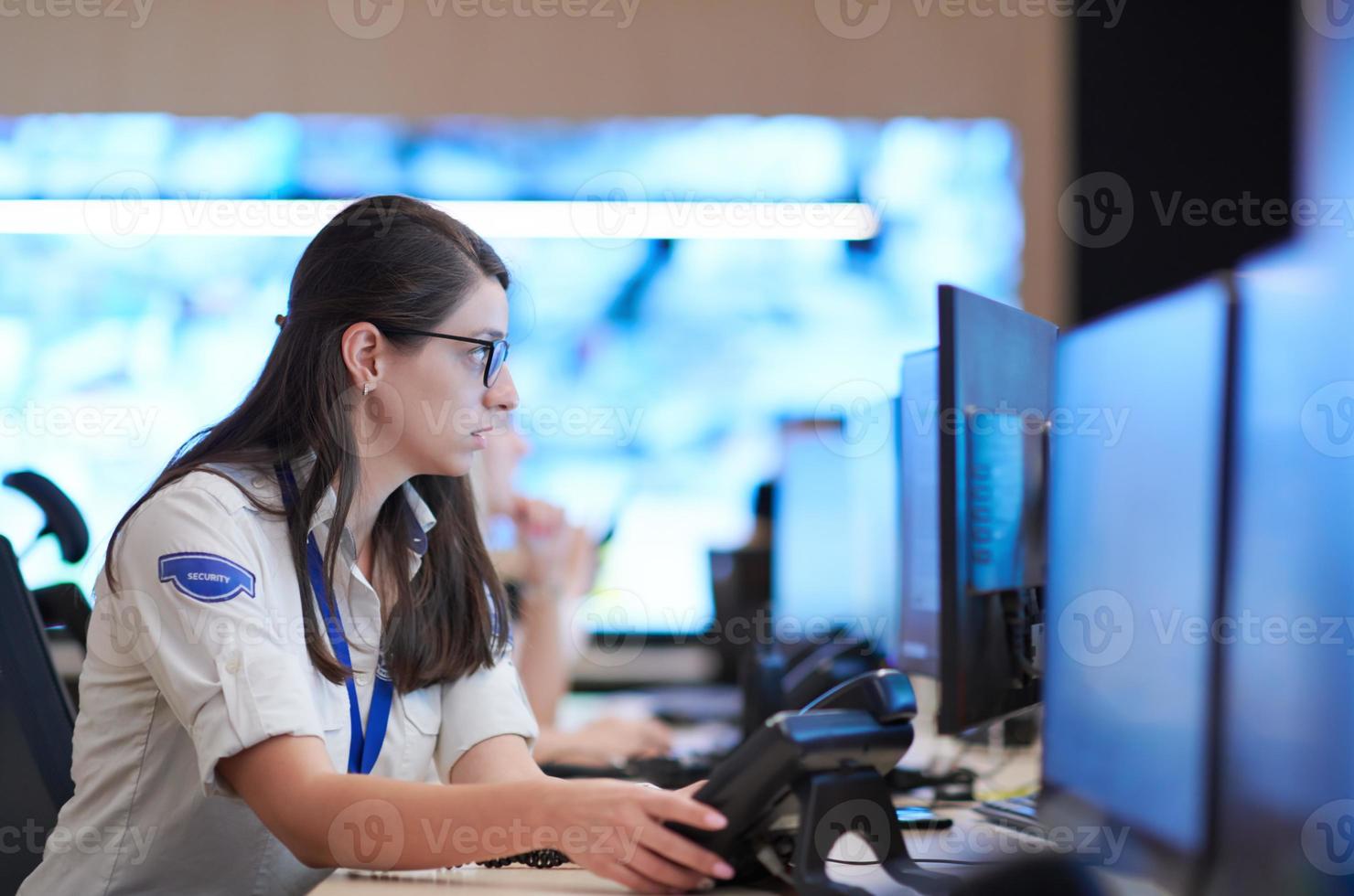 Female operator working in a security data system control room photo