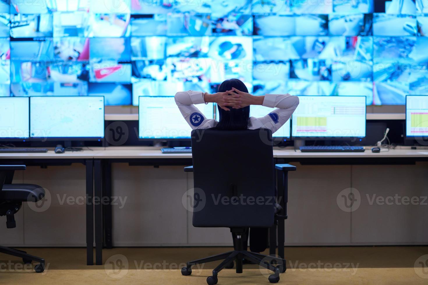 Female operator working in a security data system control room photo
