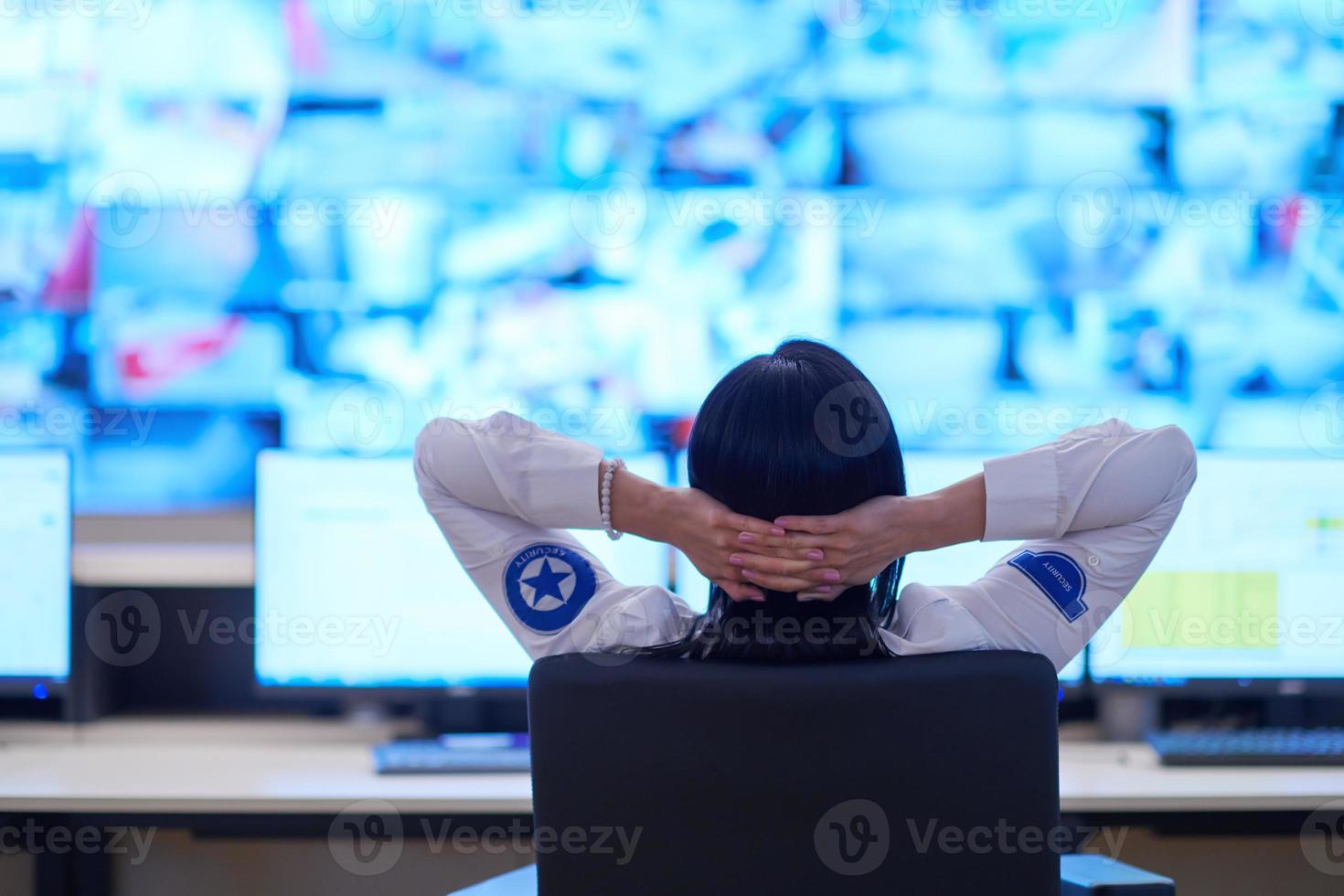 Female operator working in a security data system control room photo