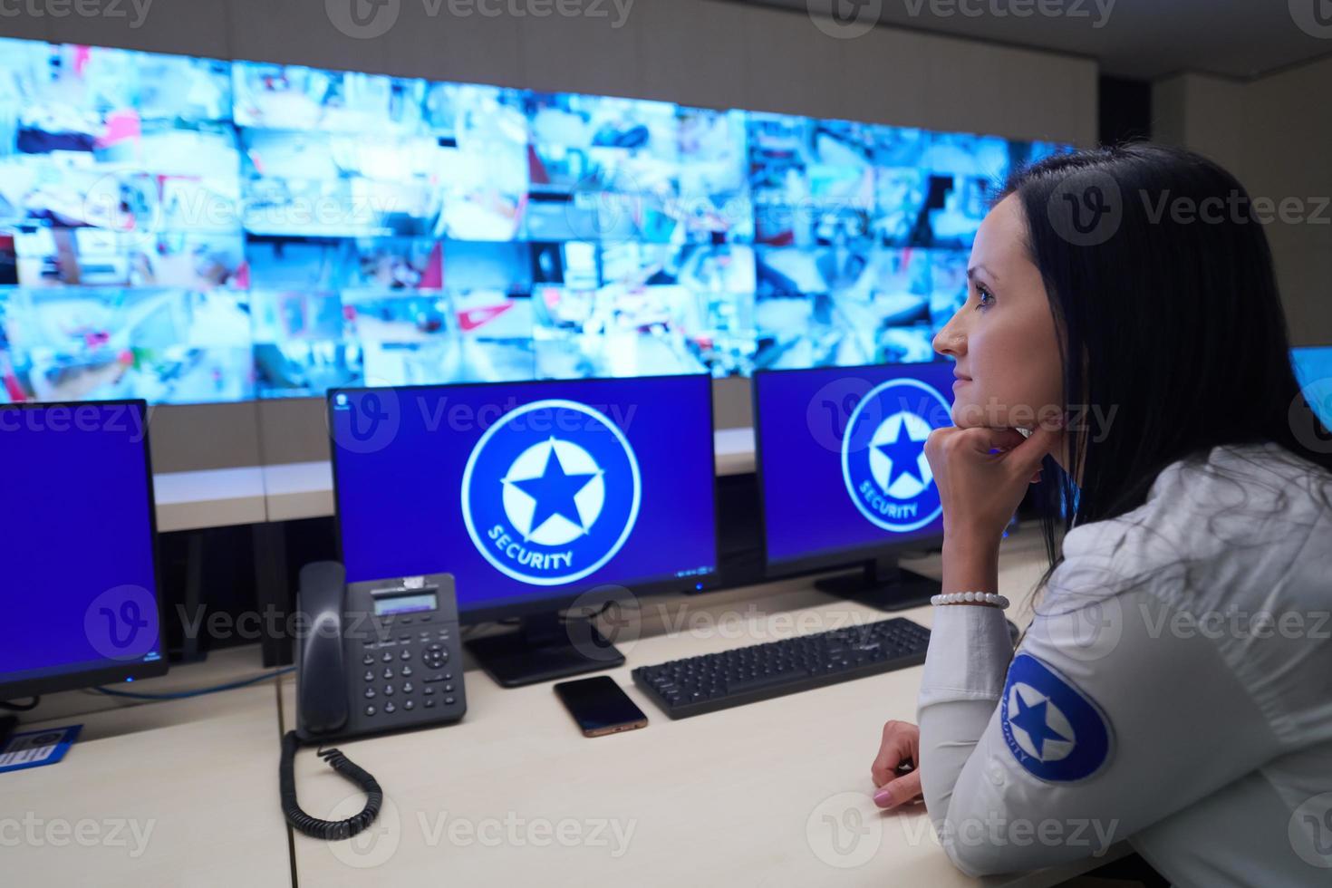 Female operator working in a security data system control room photo