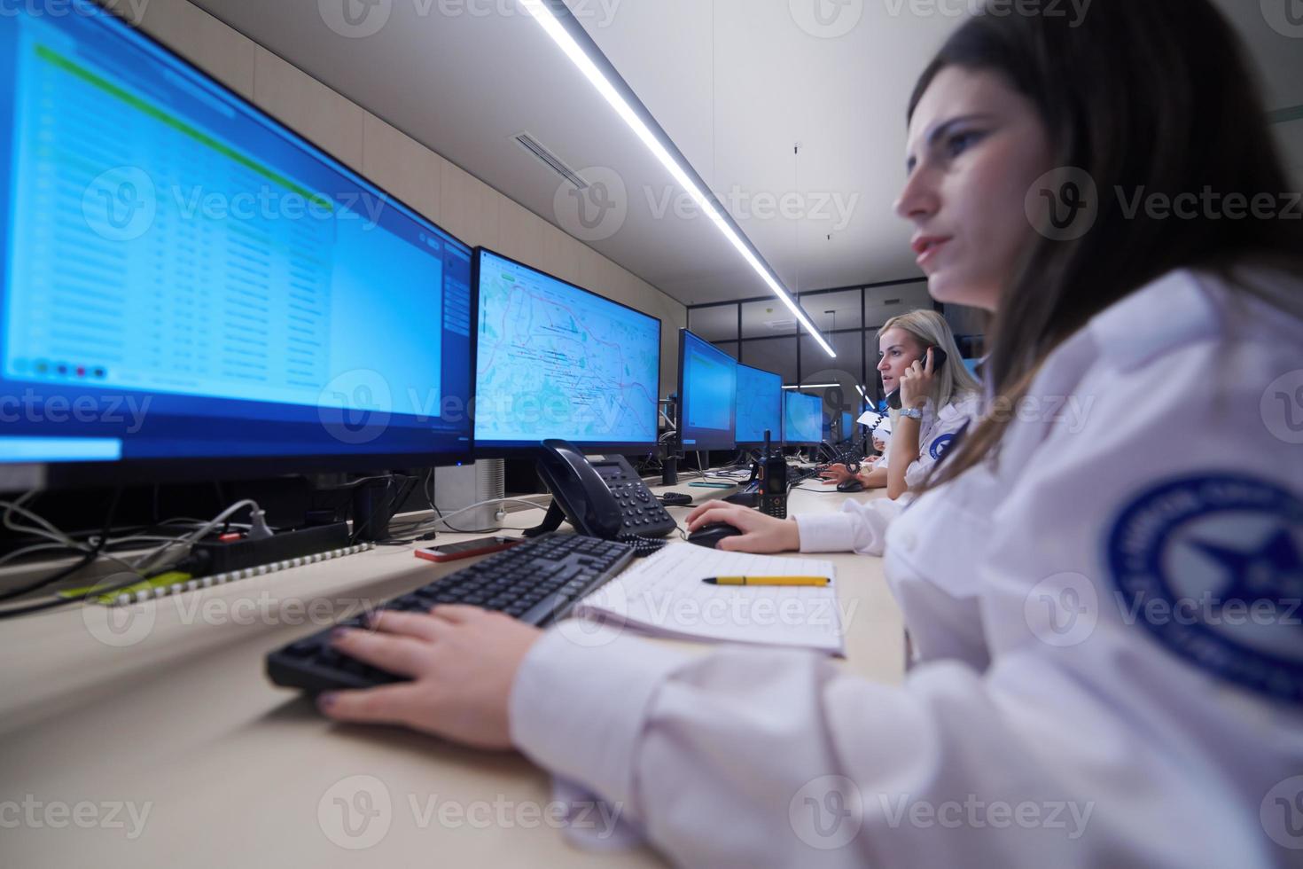 Female security guards working in a security data system control room photo