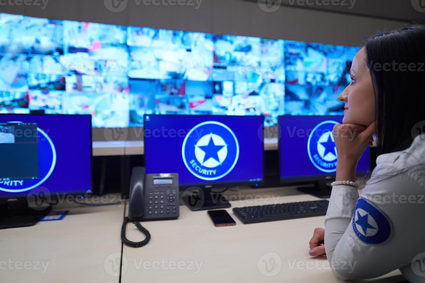 Female operator working in a security data system control room photo