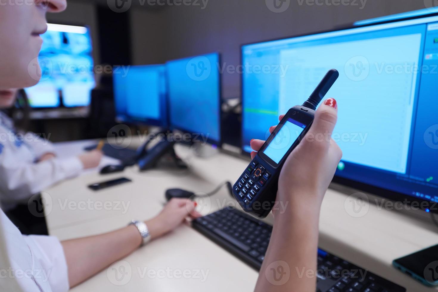 Female security operator holding portable radio in hand photo