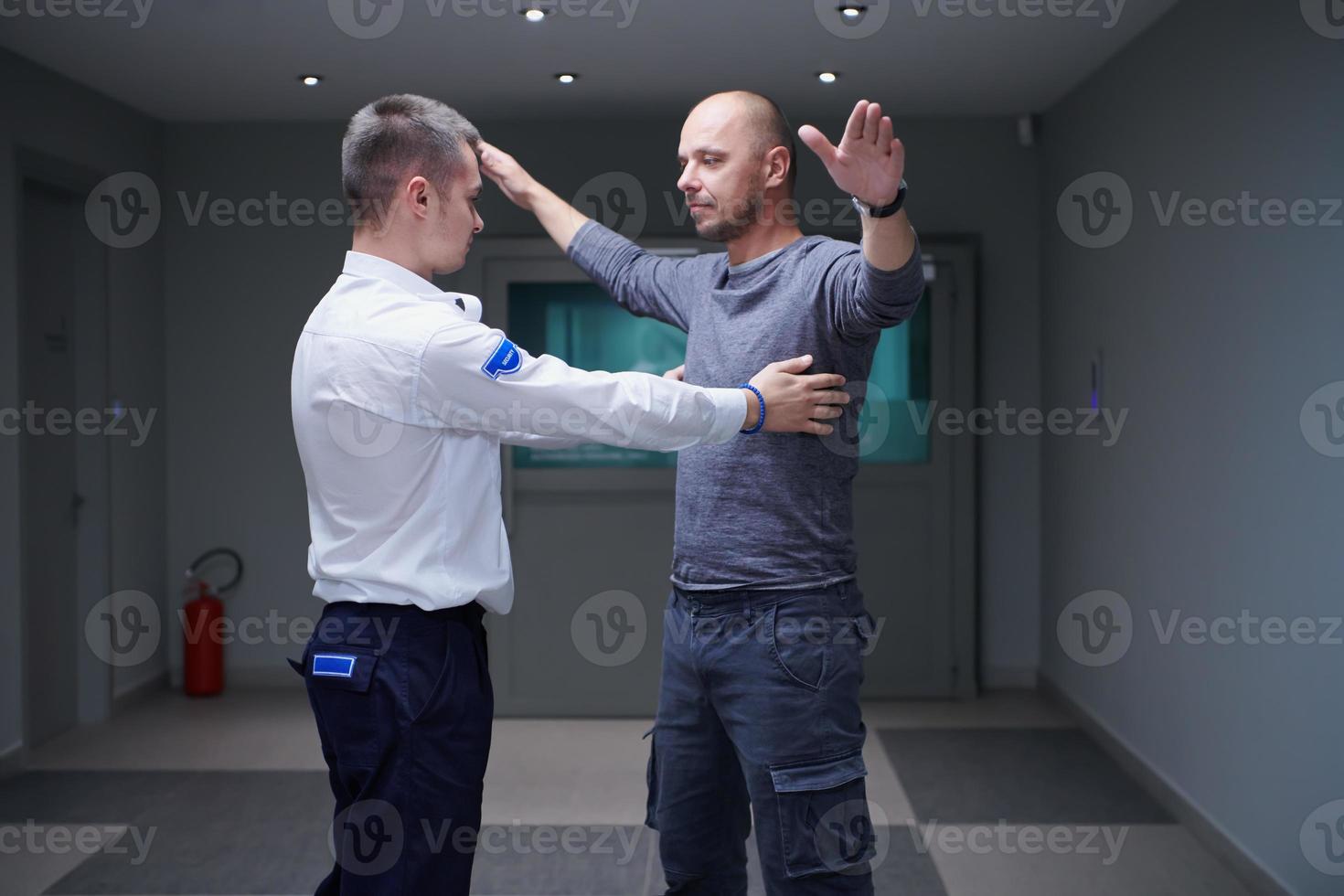 Security guard making body searching procedure on man photo