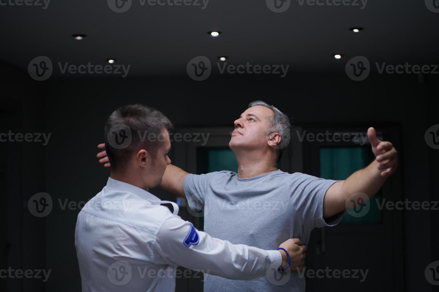 Security guard making body searching procedure on man photo