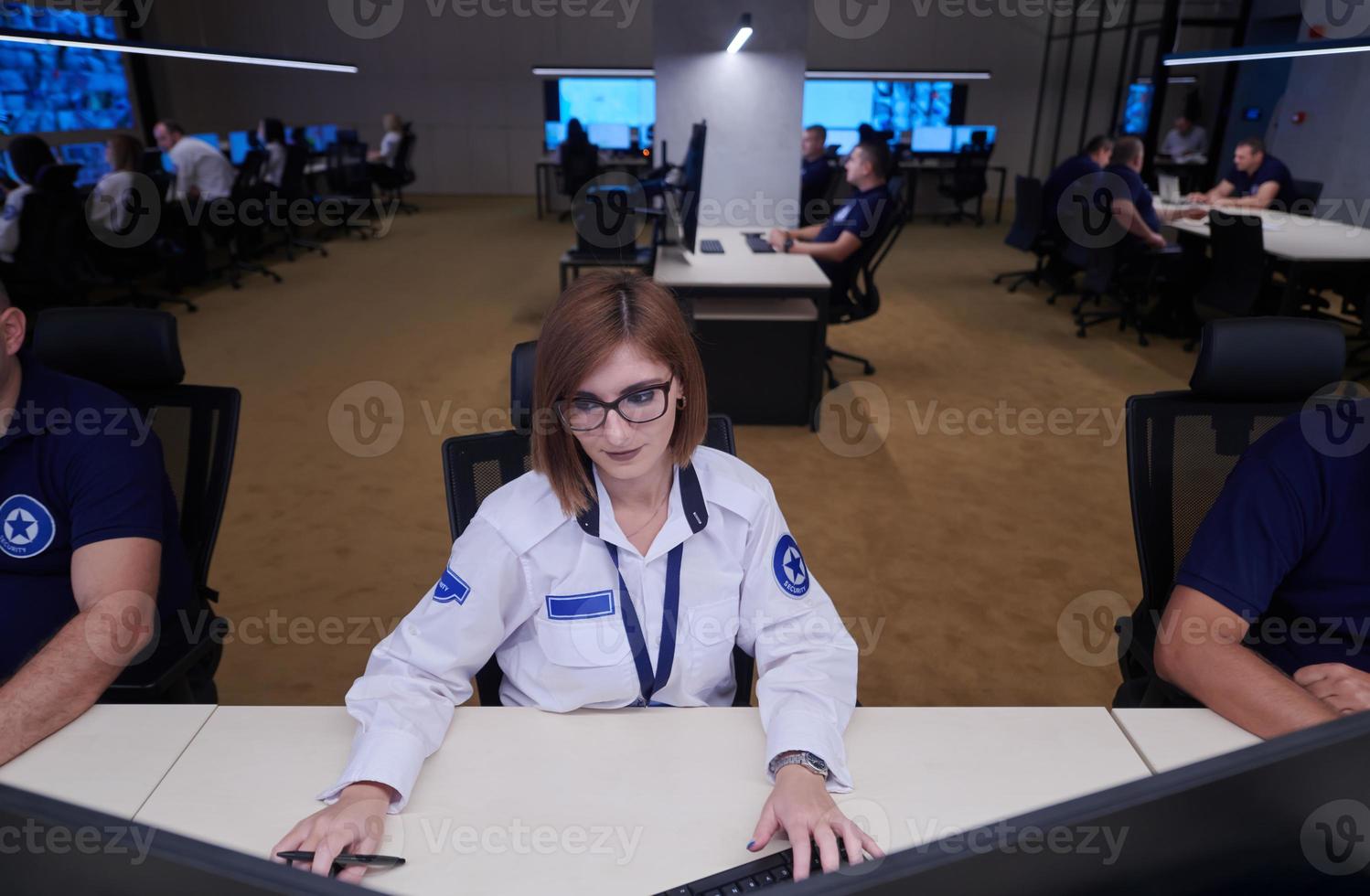 Female operator working in a security data system control room photo