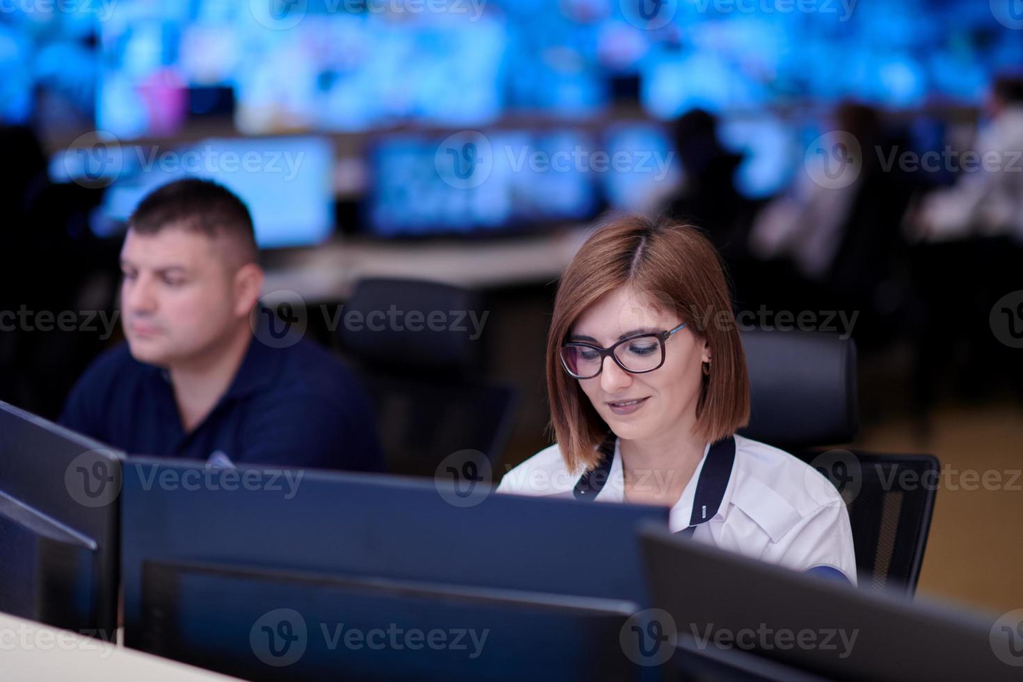 Female operator working in a security data system control room photo