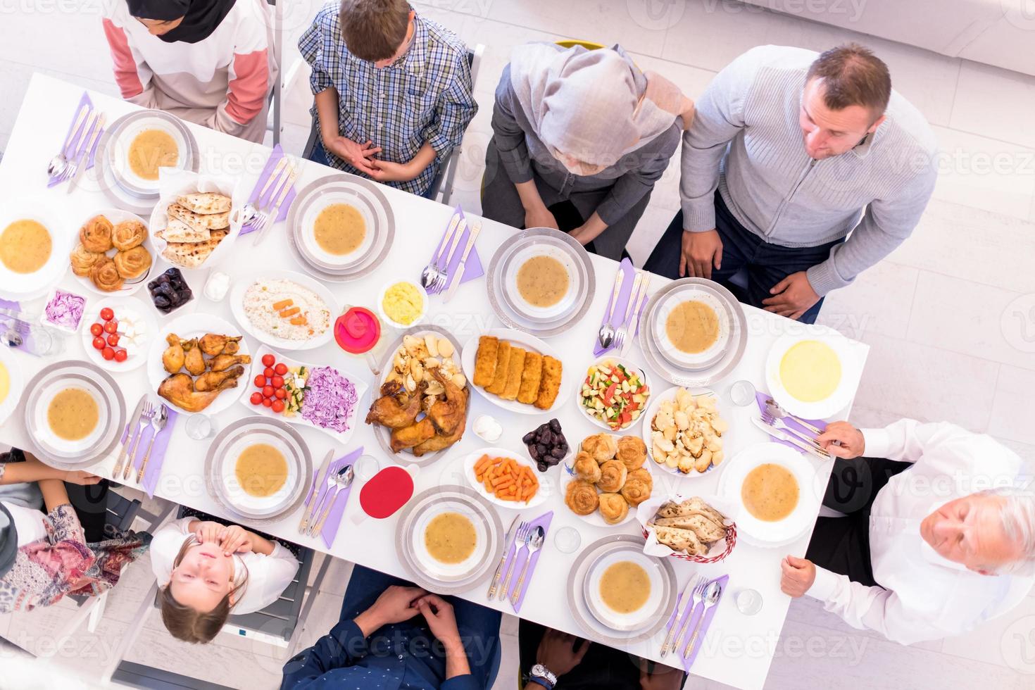 top view of modern multiethnic muslim family waiting for the beginning of iftar dinner photo