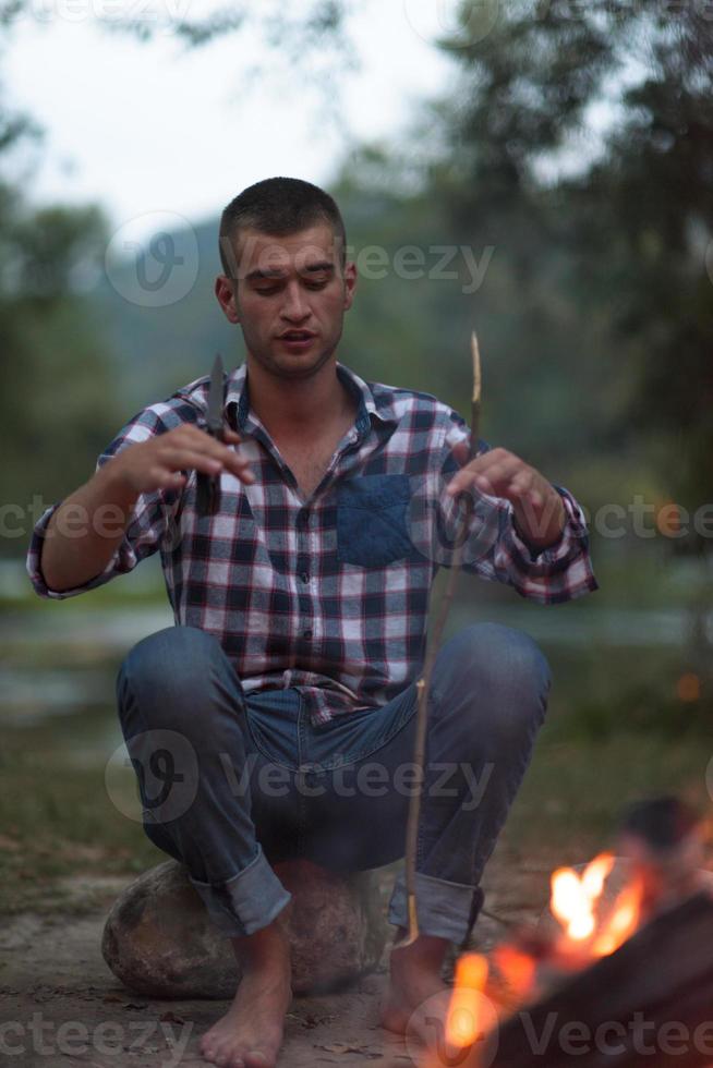 jóvenes amigos relajándose alrededor de una fogata foto