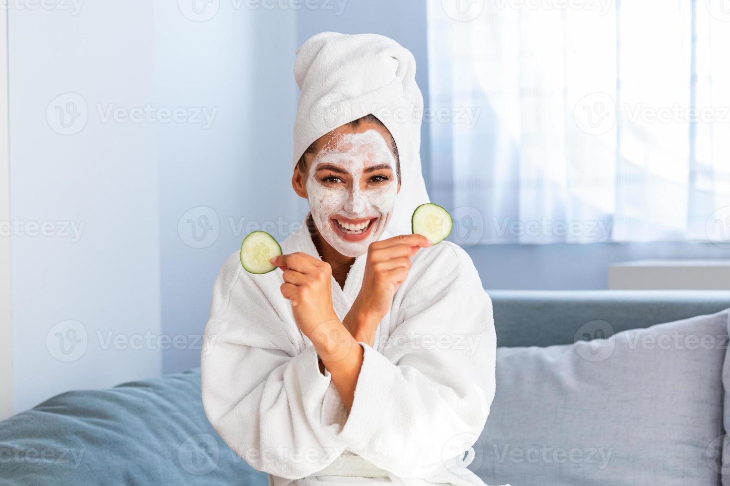 Natural homemade fresh cucumber facial eye pads facial masks. Woman holding cucumber pads and smile relax with natural homemade. Young woman with clay facial mask holding cucumber slices photo