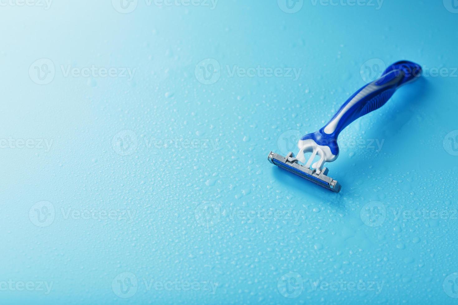 Razor blades on a blue background with drops of icy water photo