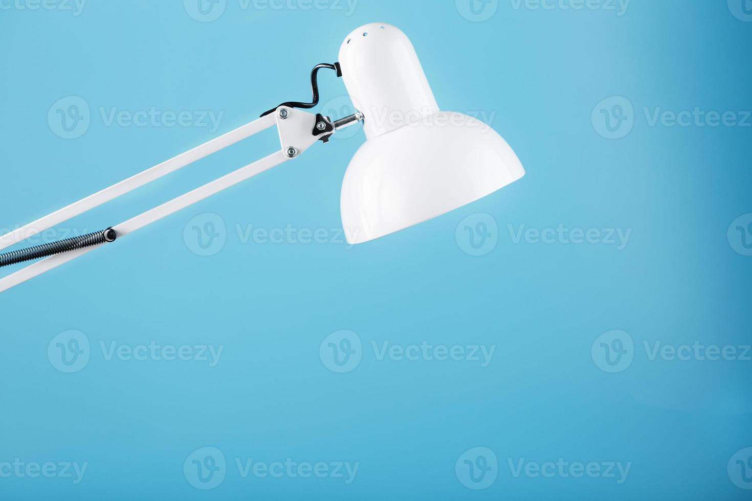 Office table lamp on blue background with space for text and idea concept photo