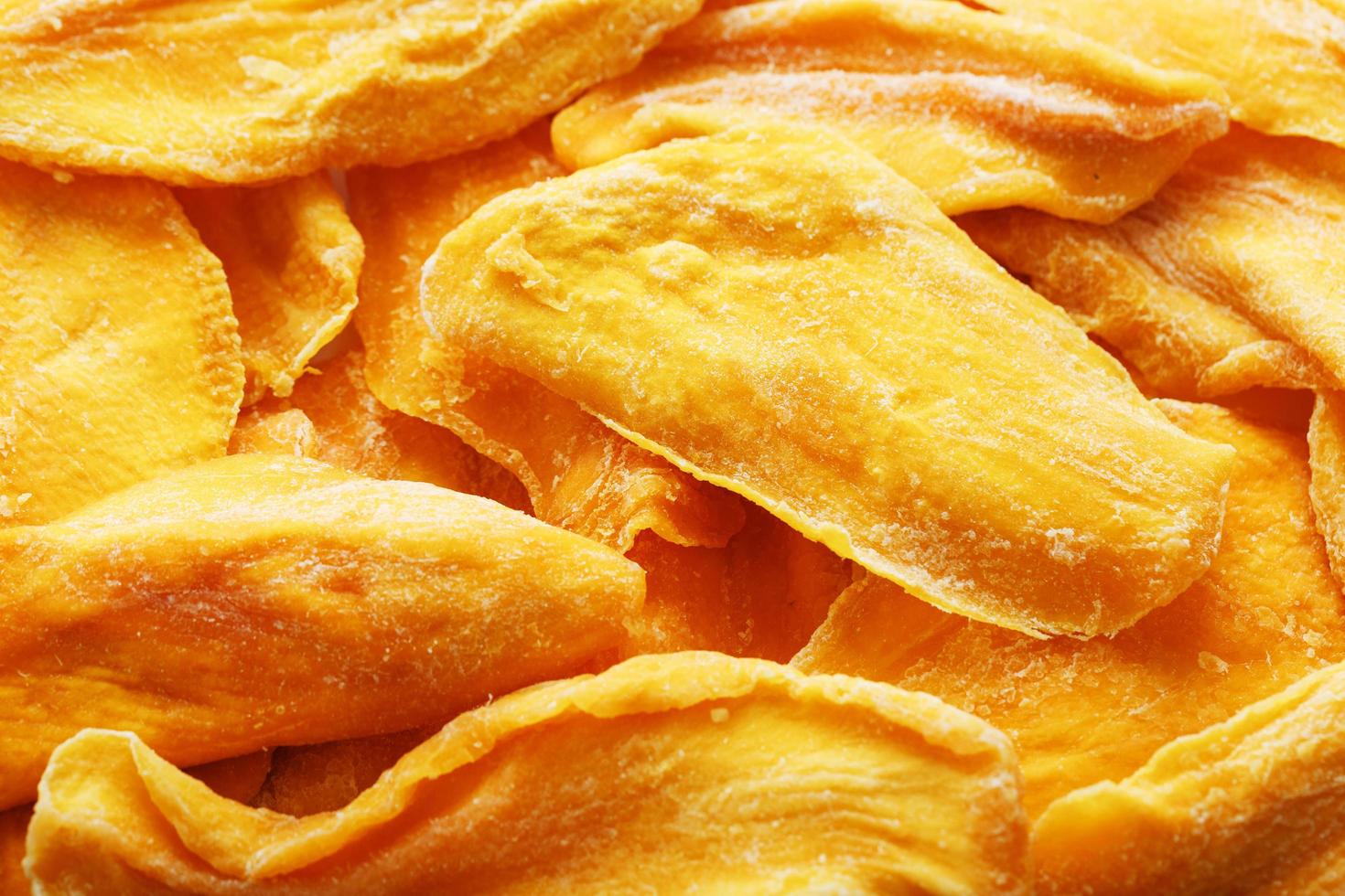 Pieces of sweet dried mango close-up as a background in full screen photo