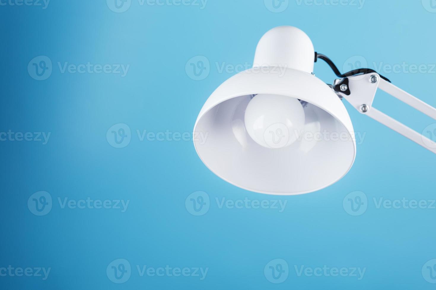 White table office lamp on blue background with space for text and idea concept photo