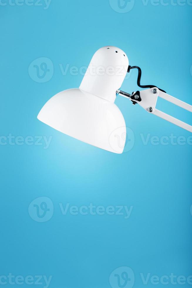 White table office lamp on blue background with space for text and idea concept photo