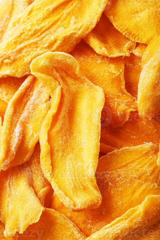 Dried sweet mango fruit slices as textural orange photo