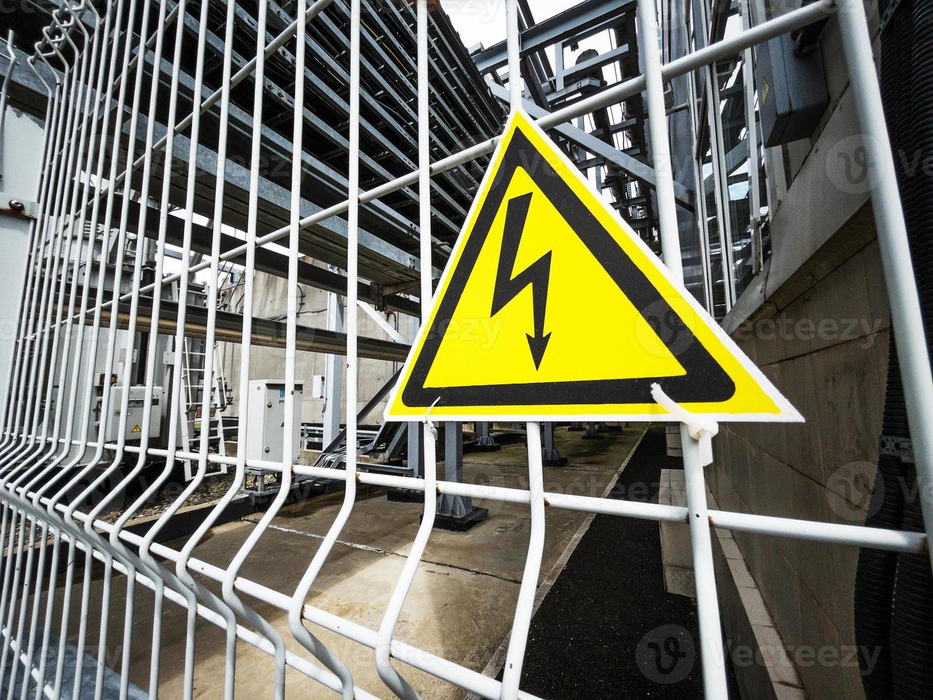 Danger Sign High voltage in a yellow triangle on a metal grid photo