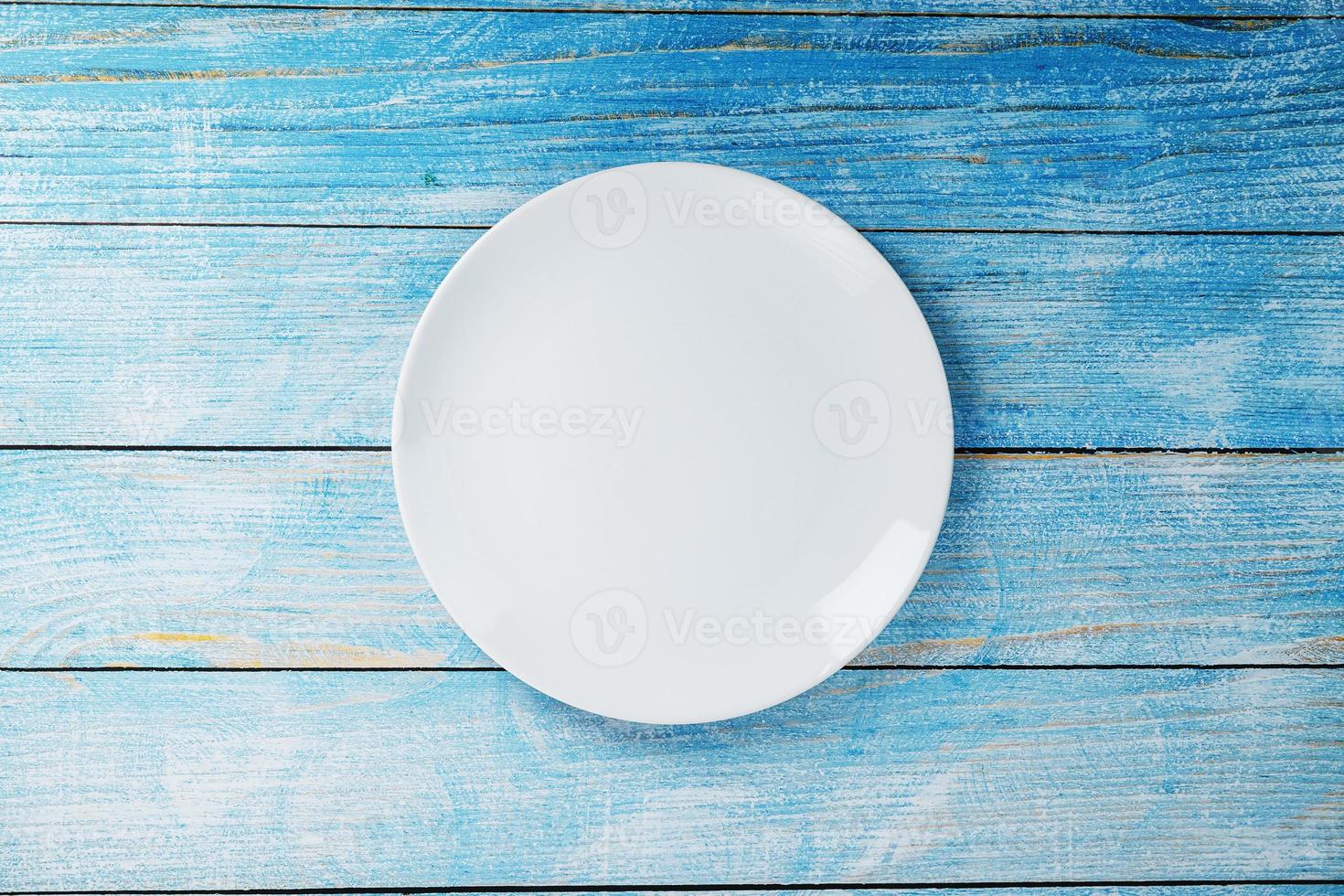 Empty round bowl on a blue wooden background from above photo