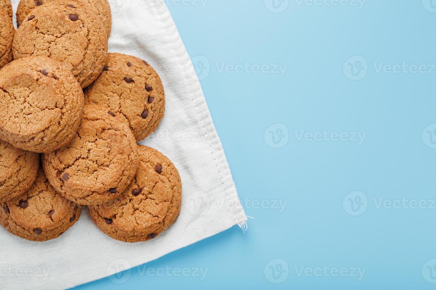 Oatmeal cookies on a blue background and a white napkin top view photo