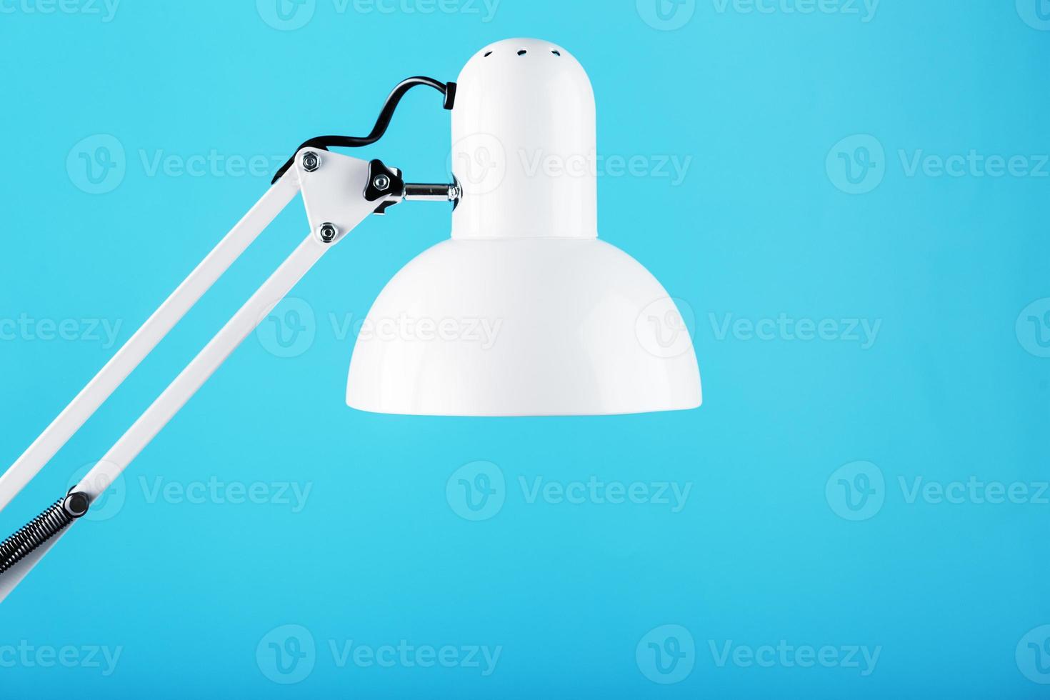 White table office lamp on blue background with space for text and idea concept photo