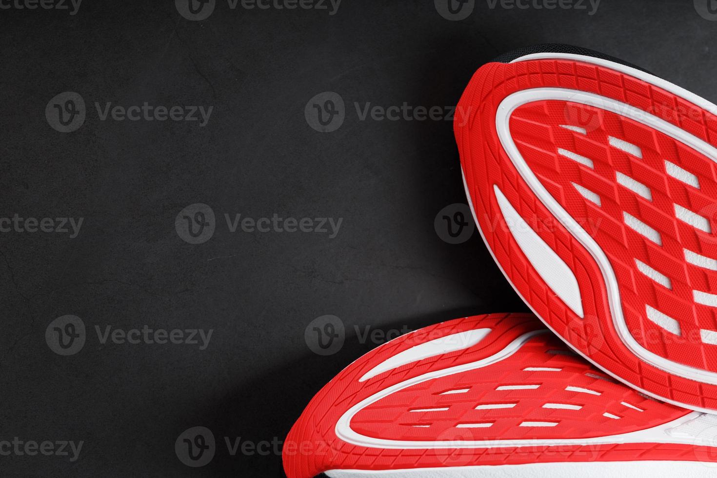 Running shoes with red soles on a black background photo