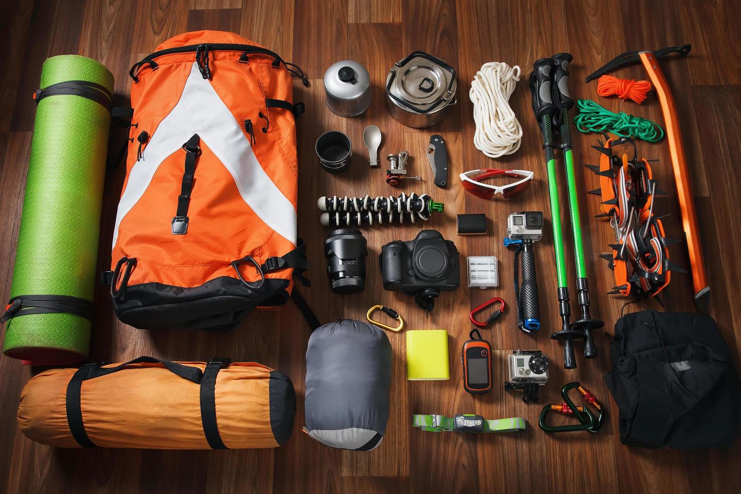 Equipment necessary for mountaineering and hiking on wooden background photo