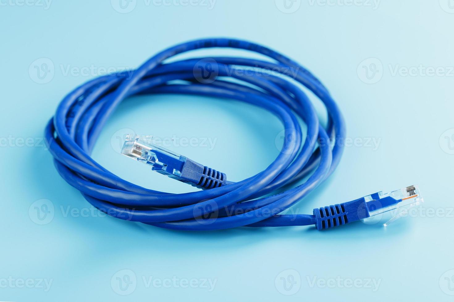 una bobina de un cable de red de Internet para la transmisión de datos sobre un fondo azul foto