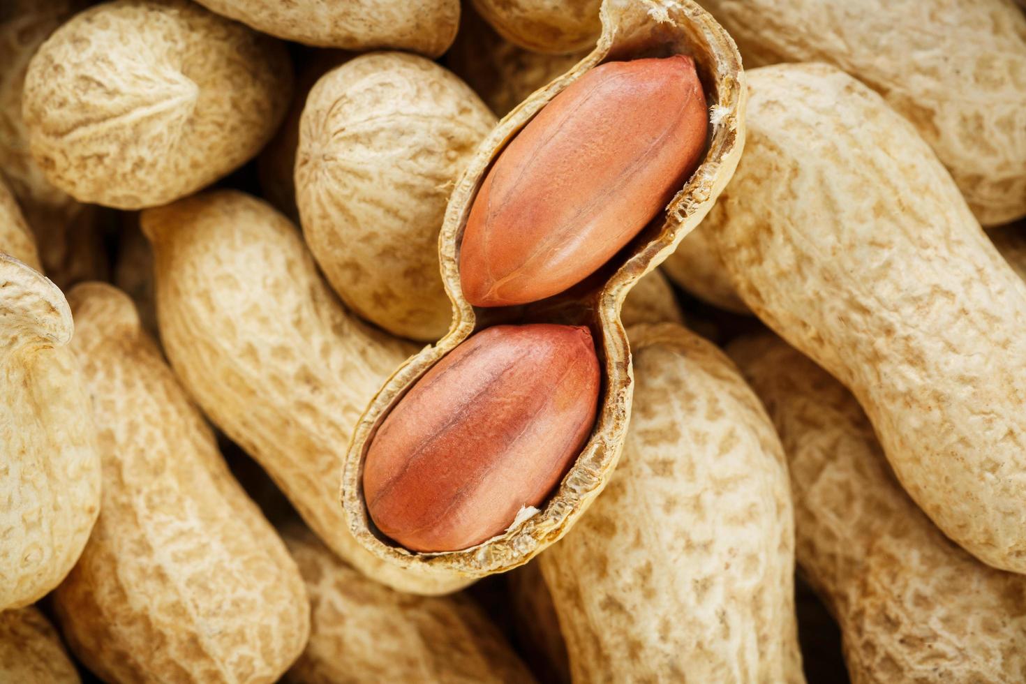 Peeled peanut on well peanuts. Peanuts, for background or textures. photo