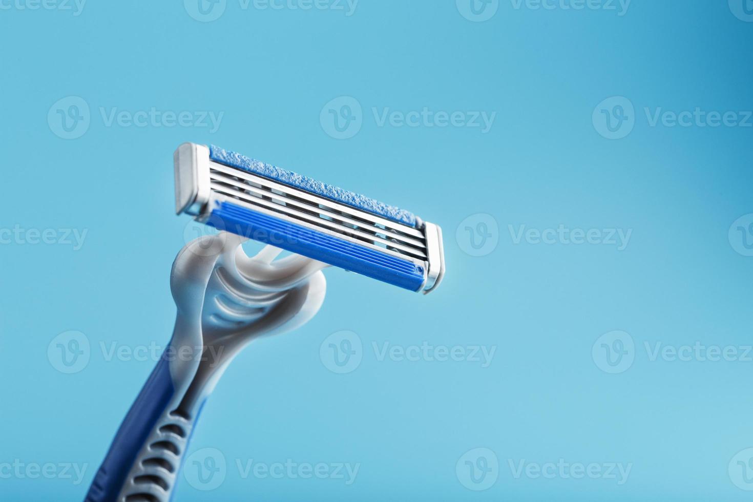 máquina de afeitar para la cara sobre un fondo azul vista superior espacio libre foto