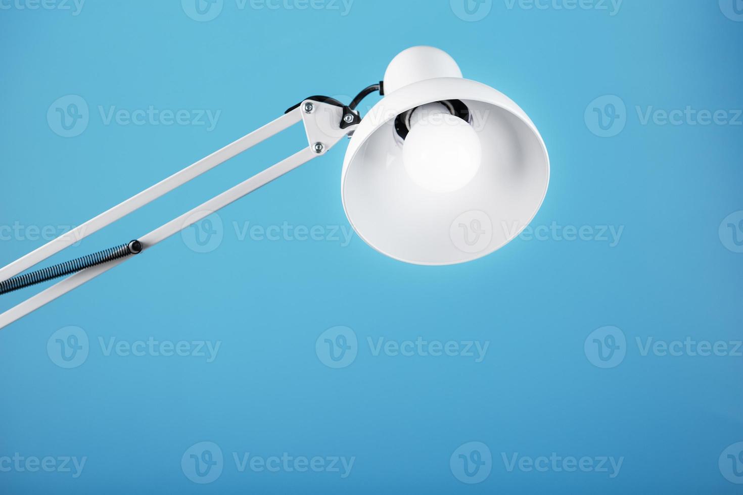 Office table lamp on blue background with space for text and idea concept photo