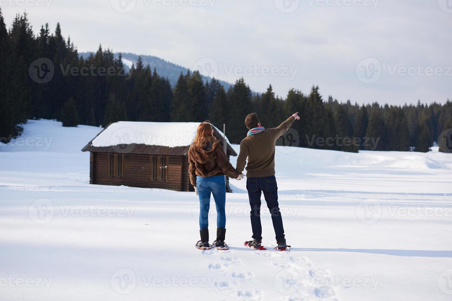 couple having fun and walking in snow shoes photo