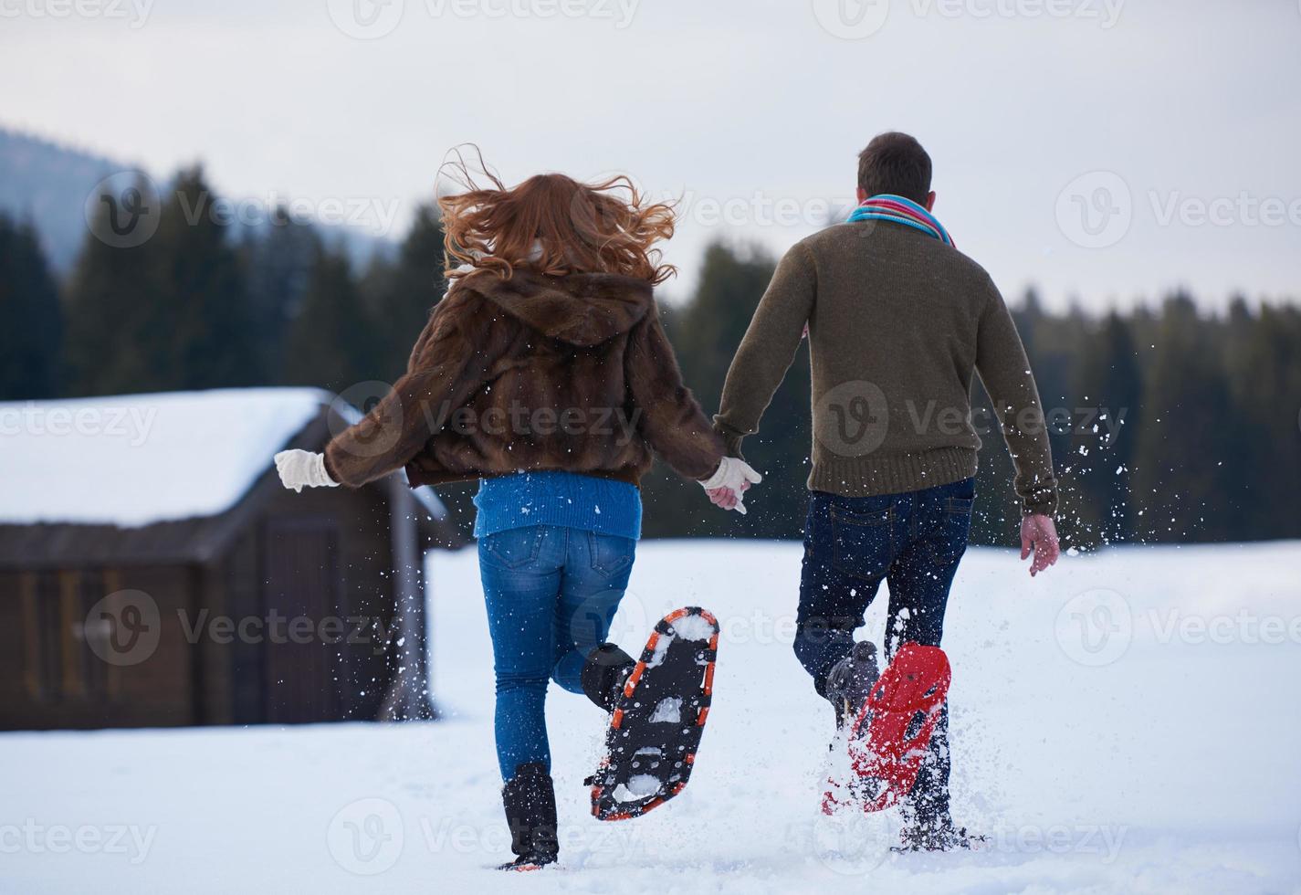 couple having fun and walking in snow shoes photo